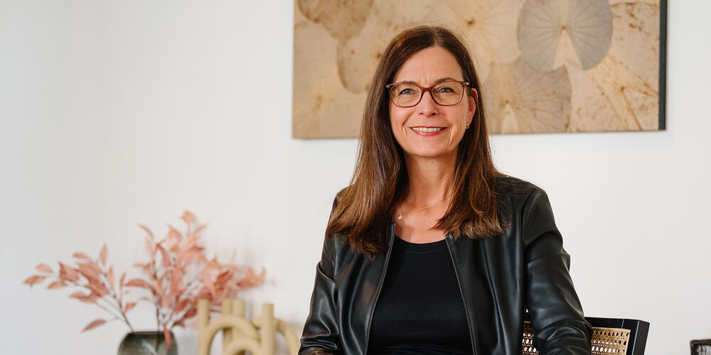 Birgit Götte sitzt auf einem Stuhl